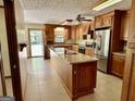Well-lit kitchen featuring wooden cabinets, stainless steel appliances, and a functional island at 183 Busbin Rd, Fayetteville, GA 30215