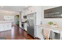 Bright kitchen featuring stainless steel appliances, granite countertops, and white cabinetry at 4402 Kady Ct, Mcdonough, GA 30252