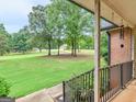 Inviting covered front porch with black iron railings, perfect for enjoying the serene views at 75 The Farm Rd, Mcdonough, GA 30252