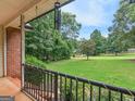 Relaxing covered front porch offering beautiful views of the lush, green front yard and trees at 75 The Farm Rd, Mcdonough, GA 30252