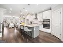 Spacious kitchen featuring white cabinets, stainless appliances, a large island with seating, and modern fixtures at 1341 Rosen Rd, Brookhaven, GA 30319