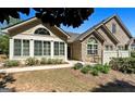 Charming single-story home featuring a stone facade, shuttered windows, patio, and well-maintained landscaping at 406 Kenley Ct, Mcdonough, GA 30253