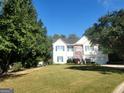 Beautiful two-story home with a well-maintained lawn and mature trees surrounding the property at 3870 Michaels Creek Ct, Loganville, GA 30052
