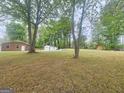 Spacious backyard with mature trees, outbuildings and plenty of room to enjoy outdoor activities at 103 Belair Ln, Stockbridge, GA 30281