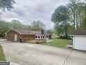 View of the back of the home with a deck, concrete patio, and a fenced backyard area at 103 Belair Ln, Stockbridge, GA 30281