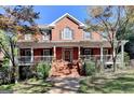 Inviting brick home with a welcoming front porch, white columns, and well-maintained landscaping at 2230 Cammie Wages Rd, Dacula, GA 30019