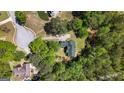 Aerial view of a home nestled among mature trees with a large backyard and a long driveway at 210 Sweetwater Dr, Fayetteville, GA 30214