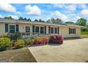 Charming home with colorful landscaping, a cozy porch, and a spacious driveway at 424 N Green Cir, Mcdonough, GA 30252