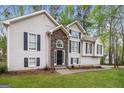 A charming two-story home showcases a stone entryway and black shutters for a classic look at 149 Camden Woods Pl, Dallas, GA 30157