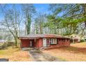 Quaint brick home with a covered carport and driveway, nestled in a wooded lot at 2595 Bonnybrook Sw Dr, Atlanta, GA 30311