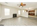 Bright living room with fireplace, modern ceiling fan, and stylish floors leading to the kitchen at 3675 Arminto Dr, Ellenwood, GA 30294