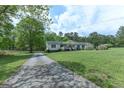 Ranch style home with covered entry and long driveway on expansive lawn at 395 Moss Ferry Rd, Villa Rica, GA 30180