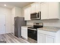 Well-lit kitchen featuring granite countertops, stainless steel appliances, and modern white cabinetry at 458 Prescott Way, Villa Rica, GA 30180