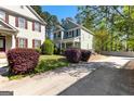 View of a two-story home with green siding, complemented by colorful landscaping and mature trees at 217 Christina Ct, Peachtree City, GA 30269