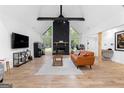 Bright open-concept living room featuring wood floors, stone fireplace, and a vaulted ceiling at 608 E Banks Rd, Fayetteville, GA 30214