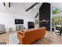 Bright living room featuring wood floors, stone fireplace, and a vaulted ceiling at 608 E Banks Rd, Fayetteville, GA 30214