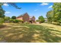 View of the backyard displaying luscious green grass, a dark fence and surrounding trees for privacy at 103 Wisteria Way, Stockbridge, GA 30281