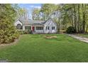 Charming single-story home with a well-manicured lawn and a welcoming red front door at 185 Cold Harbor Ct, Sharpsburg, GA 30277