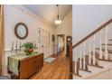 Inviting foyer boasts hardwood floors, elegant lighting, staircase, and charming decorative accents at 230 Haynes Rd, Moreland, GA 30259