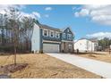 Beautiful home exterior with attached garage, long driveway, and landscaped yard at 7260 Eton Ln, Locust Grove, GA 30248
