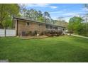 Spacious backyard showcasing lush green grass, a brick facade, and ample space at 3387 Oak Dr, Lawrenceville, GA 30044