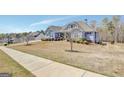 Landscaped lawn and sidewalk lead to this charming home, showcasing its blue siding and architectural details at 270 Blue Point Pkwy, Fayetteville, GA 30215
