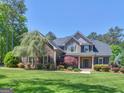 Beautiful two-story home featuring lush green lawn, mature trees and meticulous landscaping at 249 Suffolk Way, Mcdonough, GA 30252