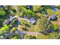 Aerial view of a home nestled among lush trees with a long driveway and expansive green lawn at 105 Hartford Pl, Fayetteville, GA 30214
