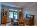 Dining room featuring a large window, hardwood floors, and a decorative chandelier at 1730 Carlington Ct, Grayson, GA 30017