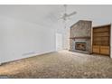 Bright living room featuring a stone fireplace, built-in shelving, and neutral carpet at 385 Lakeshore Dr, Stockbridge, GA 30281
