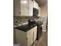 Functional kitchen with black countertops, white cabinets and stainless steel appliances at 1081 Singleton Valley Cir, Norcross, GA 30093