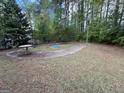 Backyard features a rundown in-ground pool surrounded by a concrete patio in a wooded setting at 9041 Southcrest Ct, Jonesboro, GA 30238