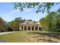 Charming traditional home with a large front lawn, mature trees, a covered front porch, and a circular drive at 240 Trotters Rdg, Fayetteville, GA 30215