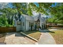 Charming home with mature trees, inviting blue door, and private driveway at 3164 Harris Dr, East Point, GA 30344