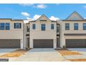 A modern townhome with a two car garage and neutral color scheme on a partially cloudy day at 1020 Sutherland Lane # 41, Lawrenceville, GA 30043