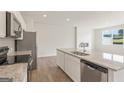 A bright open-concept kitchen with an island featuring stainless steel appliances and granite countertops at 1020 Sutherland Lane # 41, Lawrenceville, GA 30043