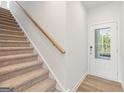 Welcoming foyer featuring a carpeted staircase and natural light at 1022 Sutherland Lane # 42, Lawrenceville, GA 30043