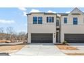 Modern townhome showcasing a two-car garage, neutral palette, and manicured landscaping on a sunny day at 1030 Sutherland Lane # 46, Lawrenceville, GA 30043