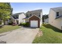 Charming two-story home with an attached brick garage and a concrete driveway leading to the front at 7756 Newbury Dr, Jonesboro, GA 30236