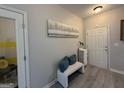 Inviting entryway with a stylish bench, modern art, and sleek, light-colored flooring at 6539 Saint Mark Way, Fairburn, GA 30213