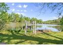 Scenic backyard featuring a lake view framed by a charming white gate and lush greenery at 30 Circle Dr, Hampton, GA 30228