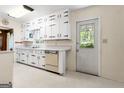 Retro kitchen featuring white cabinetry with black hardware, light countertops, and an exterior door at 30 Circle Dr, Hampton, GA 30228