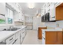 Bright kitchen featuring white cabinets, wood accents, and a stainless steel sink, with laminate flooring at 30 Circle Dr, Hampton, GA 30228