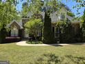 Charming brick home featuring manicured landscaping, lush trees, and a welcoming front entrance on a sunny day at 45 Anna Dr, Covington, GA 30014