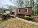 Cozy home with red trim, a small deck, and mature landscaping at 862 Bridgewater Ct, Stone Mountain, GA 30088
