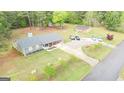 Aerial view of a well-maintained home featuring a long driveway, lush landscaping, and multiple parking spaces at 140 Stoneview Cir, Covington, GA 30016