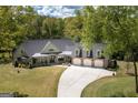 Stunning aerial view of the home showcases its well-manicured lawn, large three-car garage, and elegant exterior at 145 Carrington Ln, Brooks, GA 30205