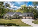 Charming home with a three-car garage, a well-manicured lawn, and a inviting front porch at 145 Carrington Ln, Brooks, GA 30205