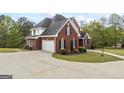 Side view of a brick home with a two-car garage, set on a large lot with a well-kept lawn at 2351 Rabbit Farm Cir, Loganville, GA 30052