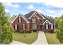 Stunning two-story brick home featuring manicured landscaping and a charming entrance at 2351 Rabbit Farm Cir, Loganville, GA 30052